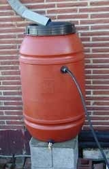 Rain barrel in front of a brick wall